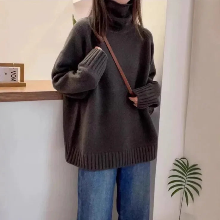 Women's loose fit red turtleneck sweater with a thick 3D curling pile collar on a neutral background.