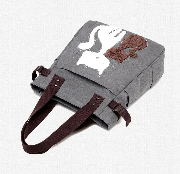 KVKY canvas handbag with plush cat applique in beige colour on a woman's shoulder