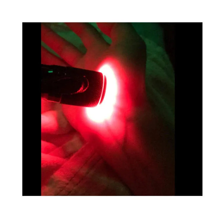 Black aluminium Smart Vein Locator device with red LED lights on, showing size against a hand.