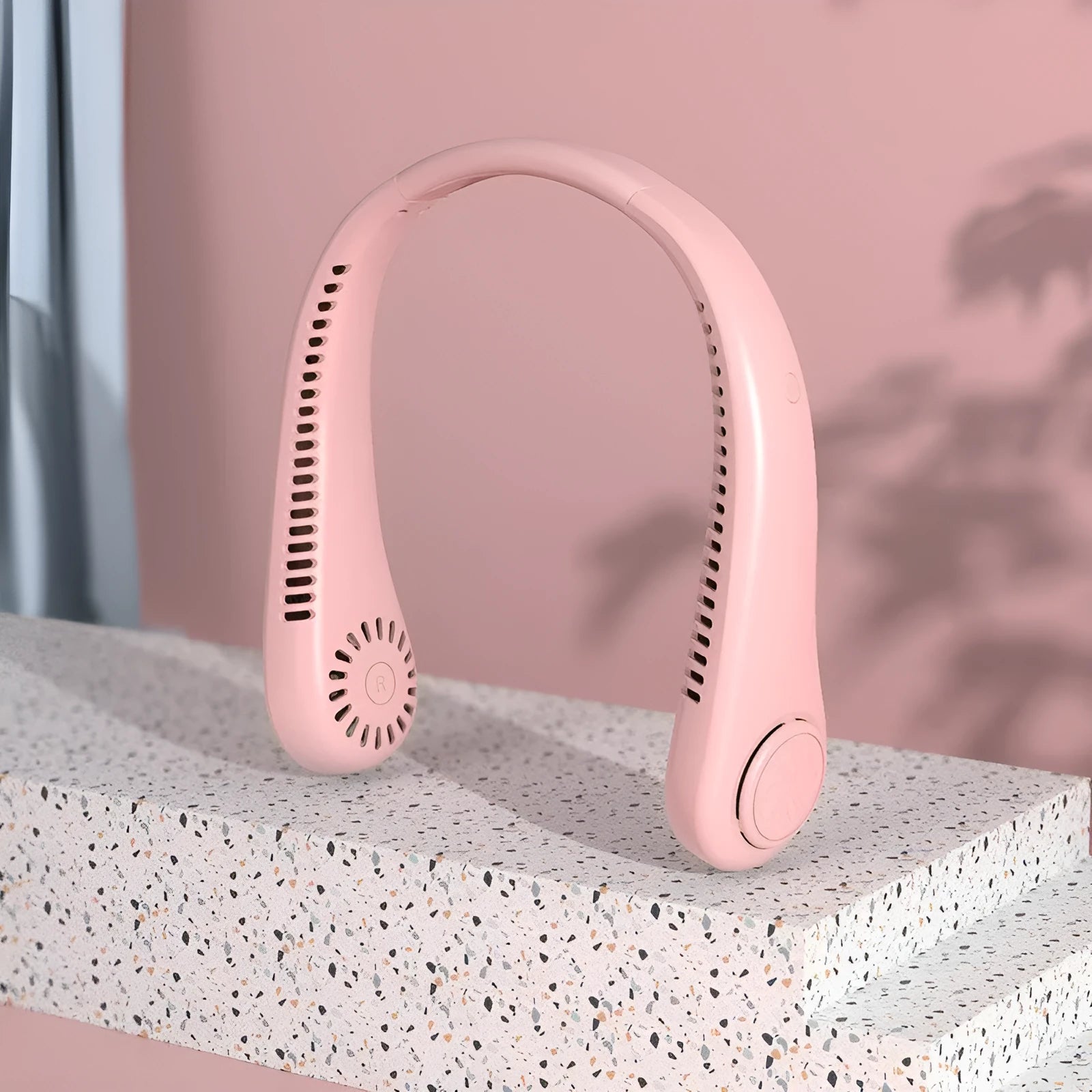 Pink portable bladeless neck fan with USB charging cable and adjustable speed control