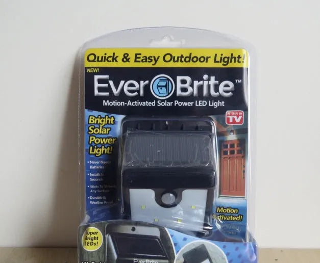 White solar-powered outdoor wall light with four LEDs and adjustable solar panel for motion-activated garden security