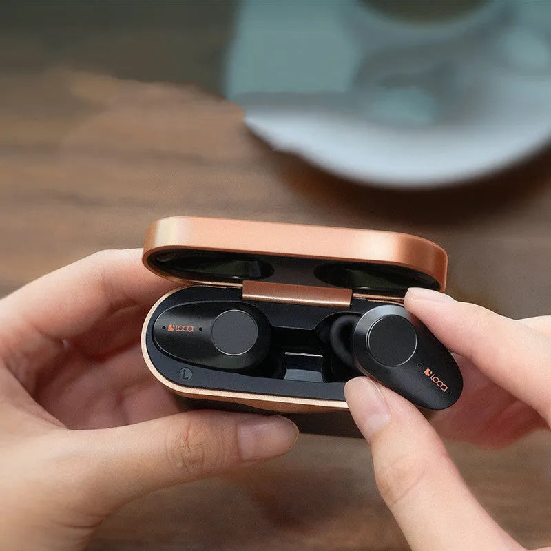Black wireless Bluetooth headphones with charging stand on a table