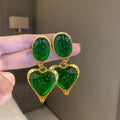 A pair of oval-shaped heart stud earrings with a silver needle texture in purple, red, green, and yellow white colours