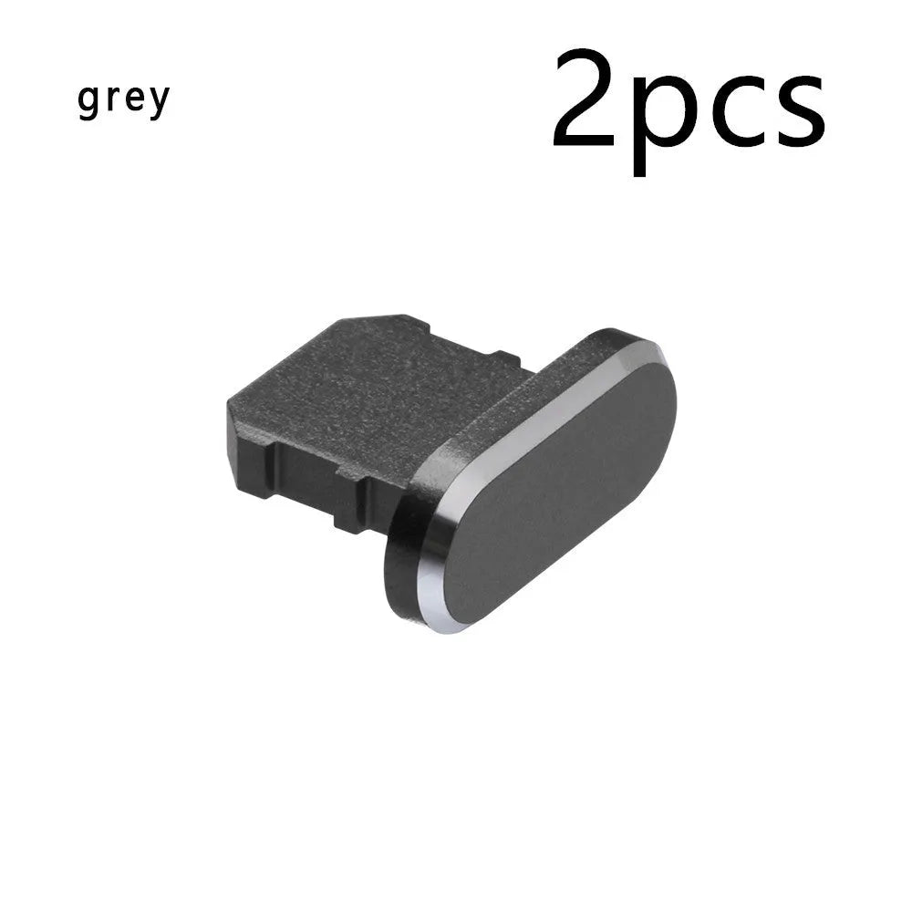 Aluminium alloy iPhone charging port dust plug in metallic colours on a dark background.