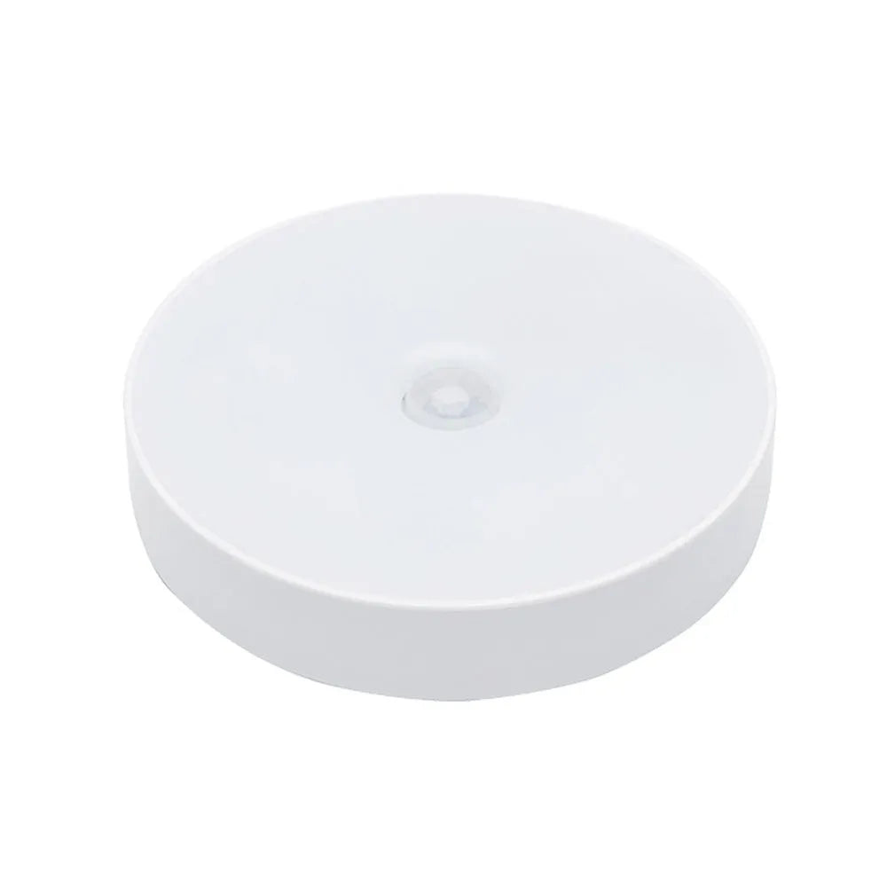 Small round motion sensing night light with USB charging port and adhesive backing