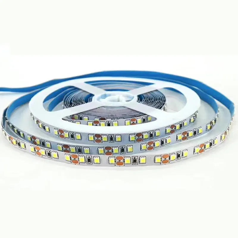 Close-up of a flexible white LED light strip with dense SMD LEDs, shown coiled, for shelf and counter lighting.