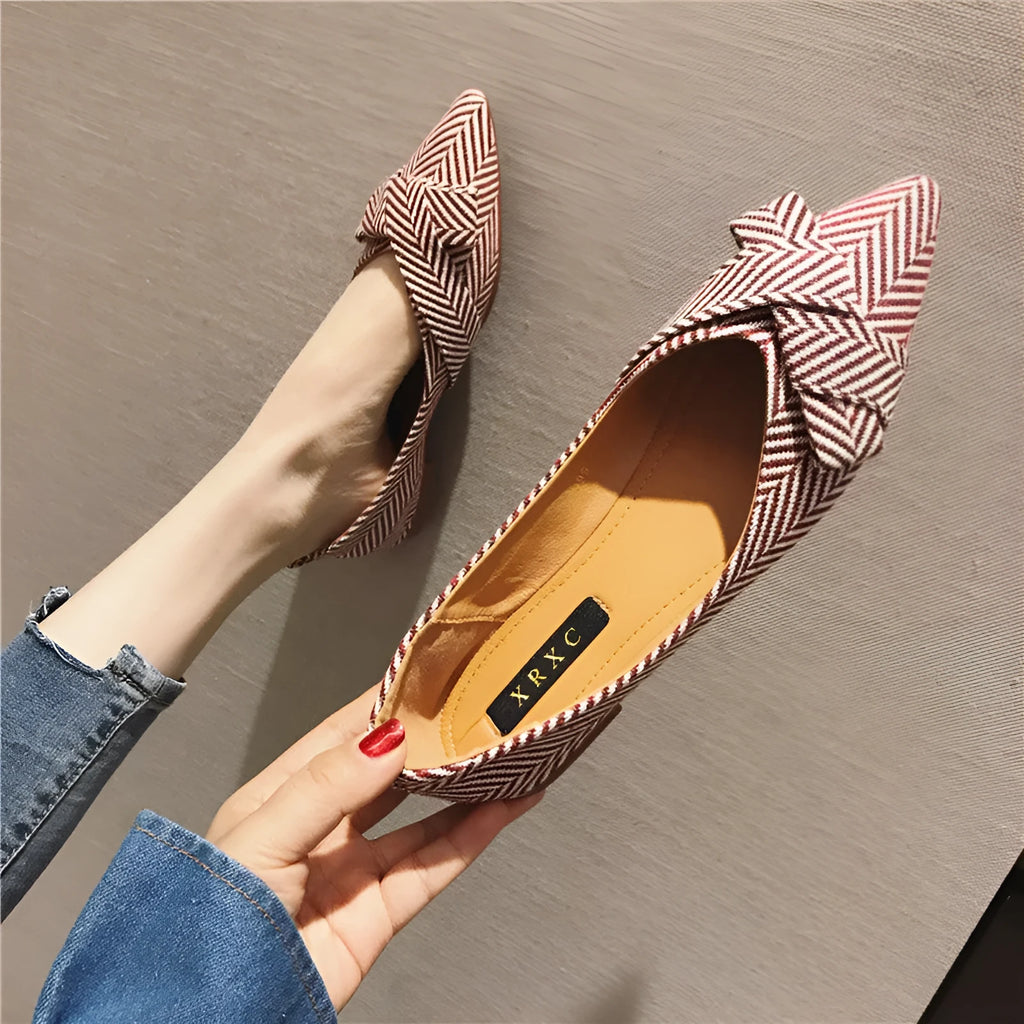 Women's pointed toe ballet flats in black with shallow mouth design and low flat heel.
