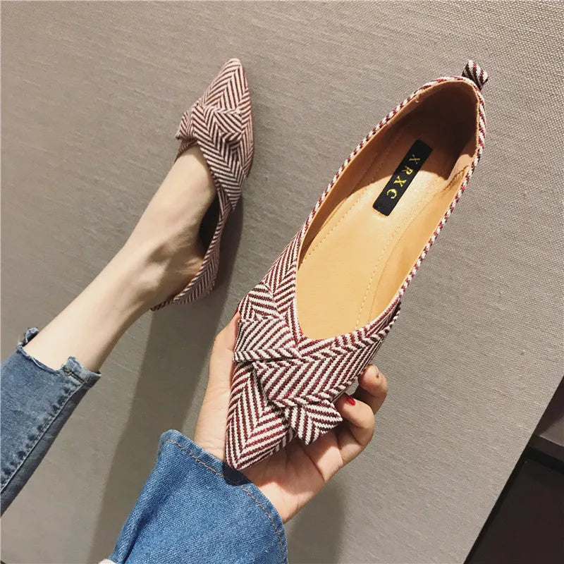 Women's pointed toe ballet flats in black with shallow mouth design and low flat heel.