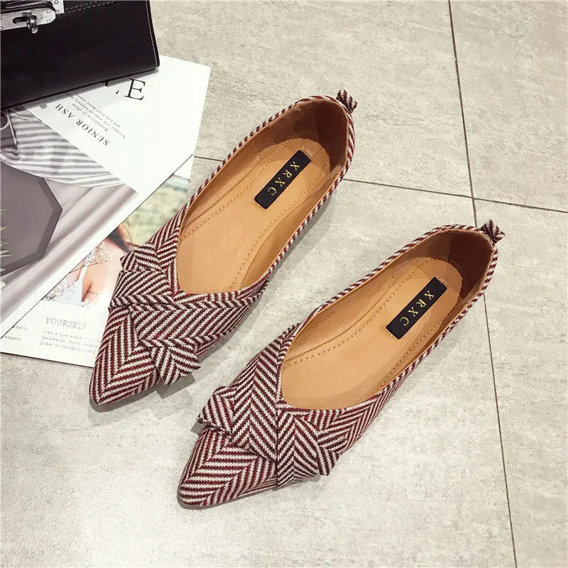 Women's pointed toe ballet flats in black with shallow mouth design and low flat heel.