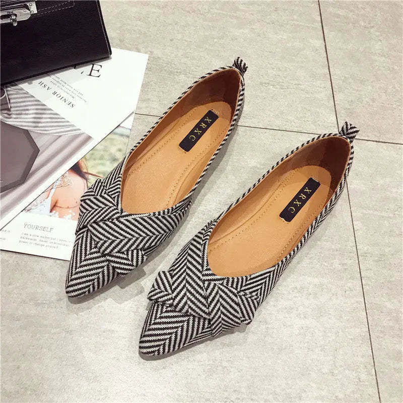 Women's pointed toe ballet flats in black with shallow mouth design and low flat heel.