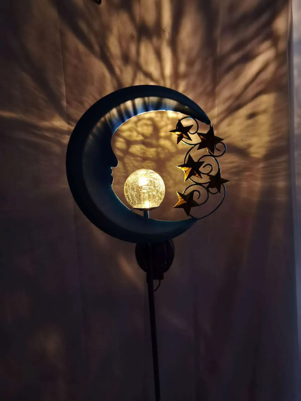 Solar-powered blue moon garden light with wrought iron frame and glass ball