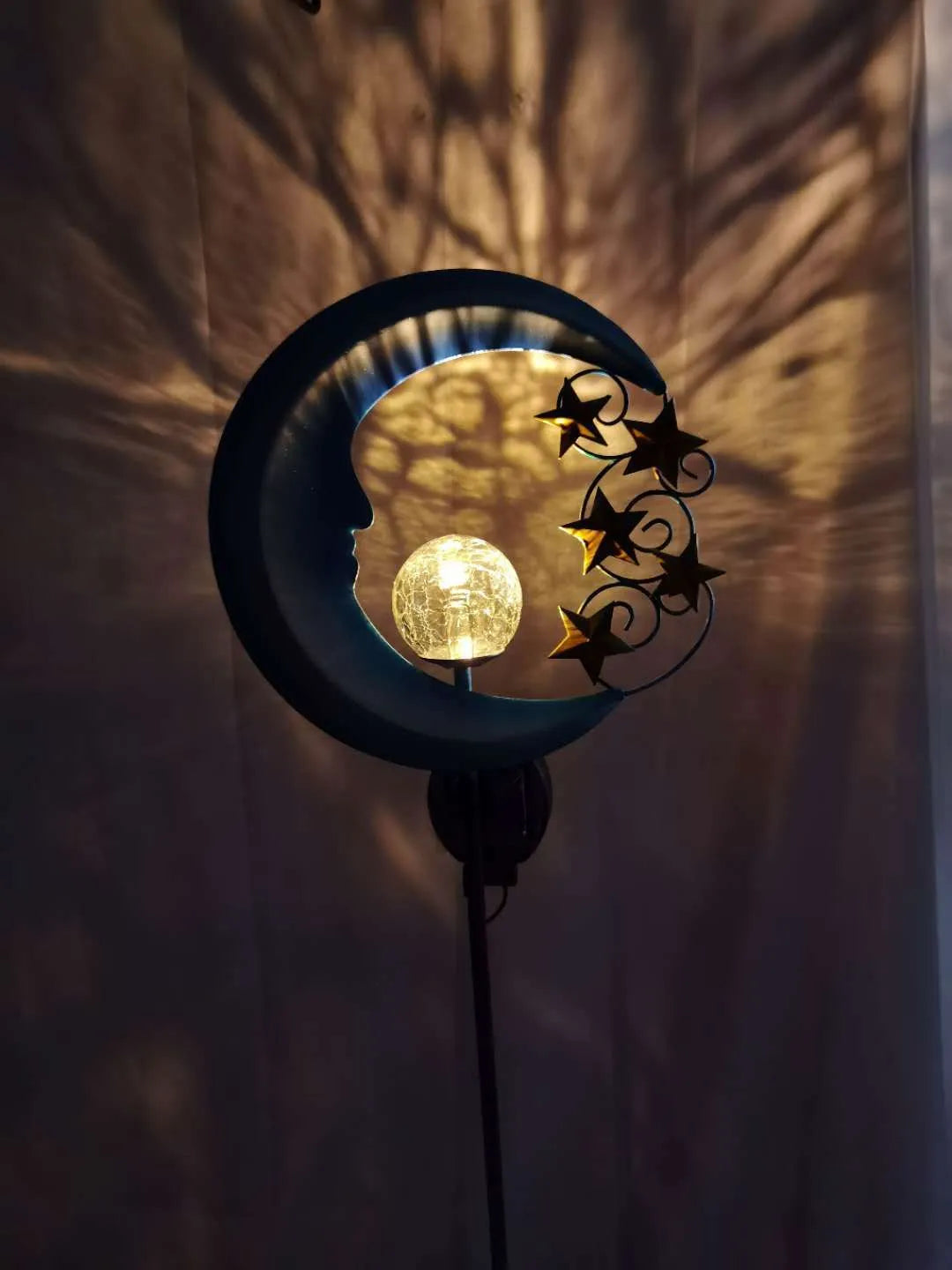 Solar-powered blue moon garden light with wrought iron frame and glass ball