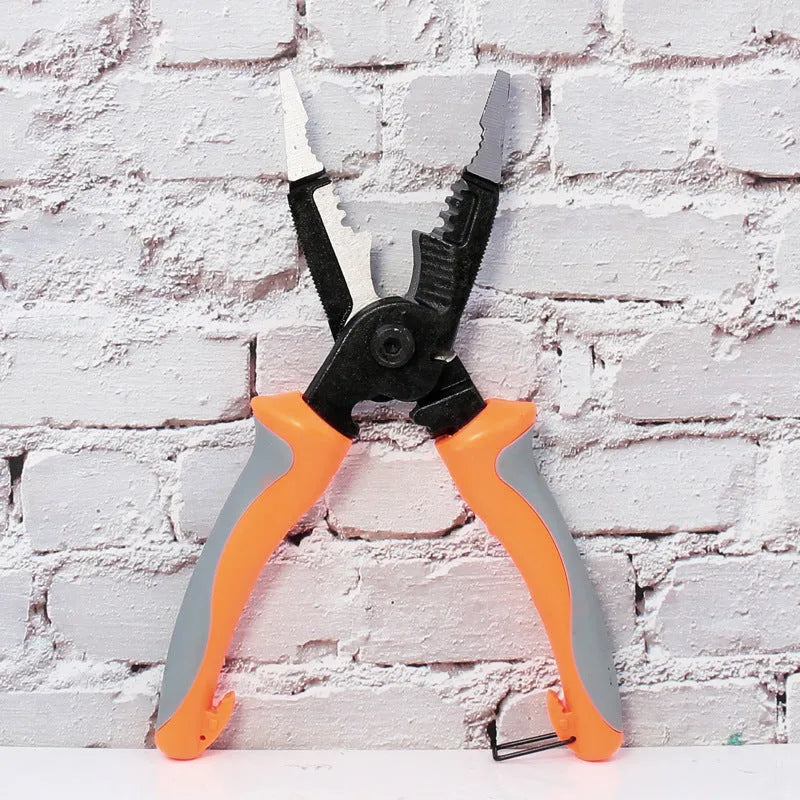 Orange multifunctional electrician's pliers and wire stripper tool with duckbill head on a workbench.