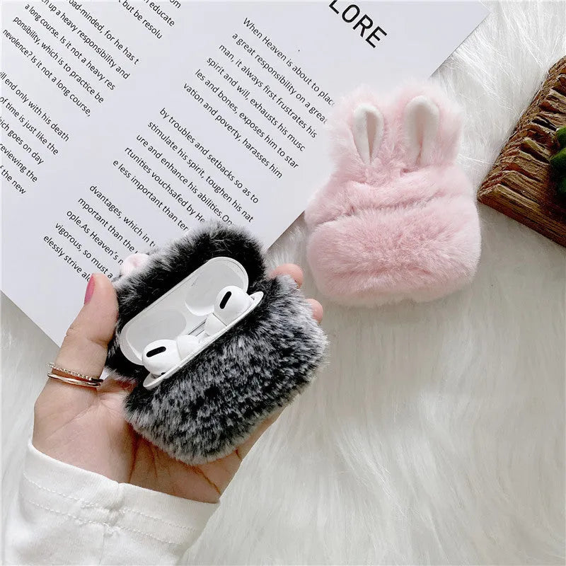 Pink silicone AirPods case cover with raised rabbit ears on a grey background.