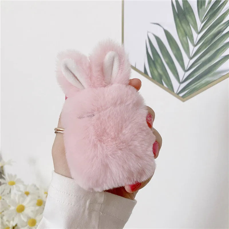 Pink silicone AirPods case cover with raised rabbit ears on a grey background.