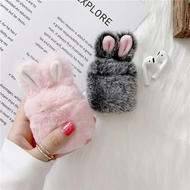Pink silicone AirPods case cover with raised rabbit ears on a grey background.
