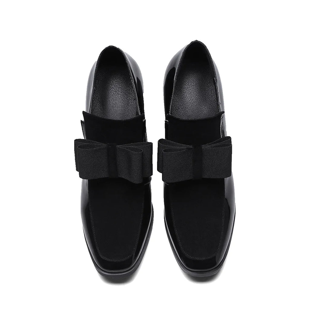 Black patent leather high heels with a thick block heel and square toe on a white background.