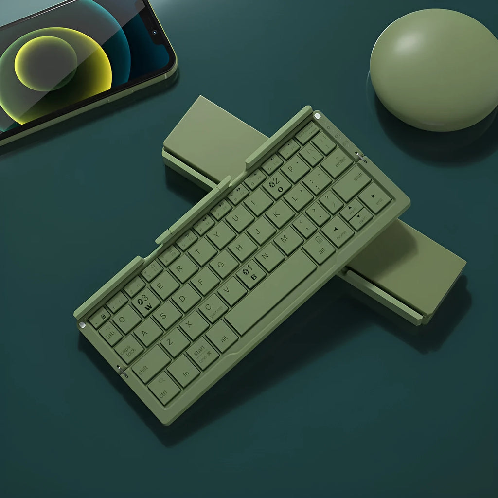 Aluminium folding Bluetooth keyboard with stand supporting smartphone, showing compact folded size
