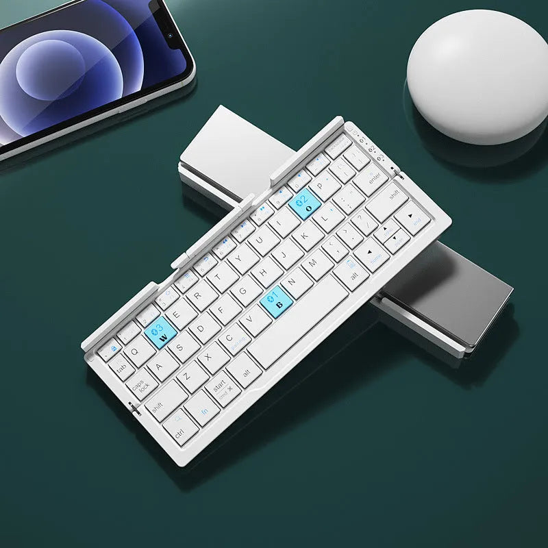 Aluminium folding Bluetooth keyboard with stand supporting smartphone, showing compact folded size
