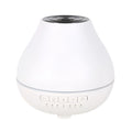White round Bluetooth aromatherapy humidifier diffuser with LED night light on a wooden surface