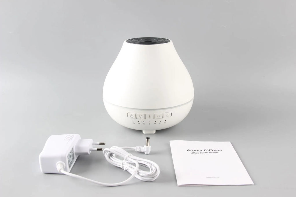 White round Bluetooth aromatherapy humidifier diffuser with LED night light on a wooden surface