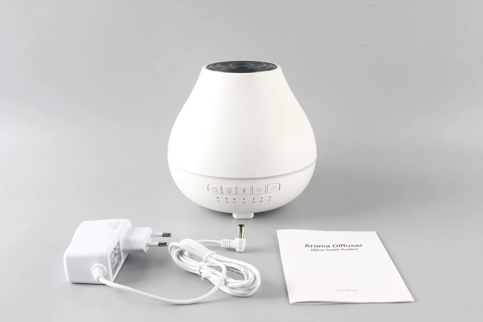 White round Bluetooth aromatherapy humidifier diffuser with LED night light on a wooden surface