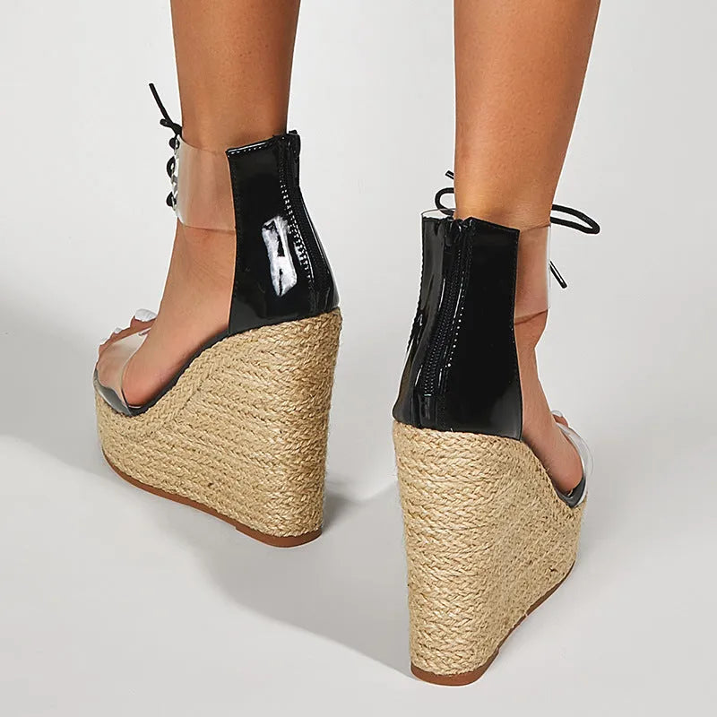 Black women's wedge sandals with hemp rope detail on a super high platform heel and front tie closure.