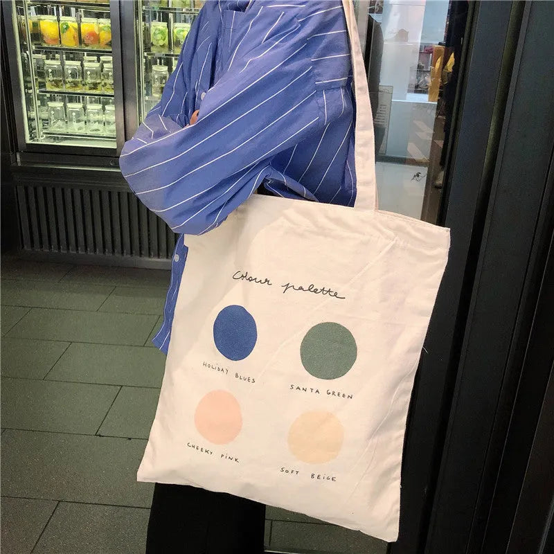 Women's medium canvas tote bag with geometric pattern, zipper closure, and shoulder straps in orange or light pink colour