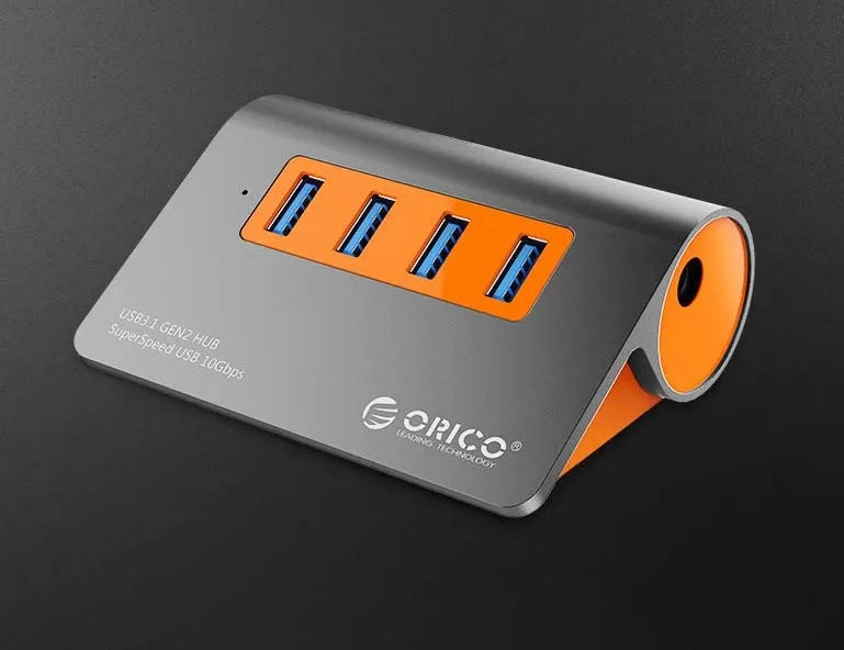 Dark grey and orange aluminium laptop USB hub with four USB 3.1 ports and a detachable cable.