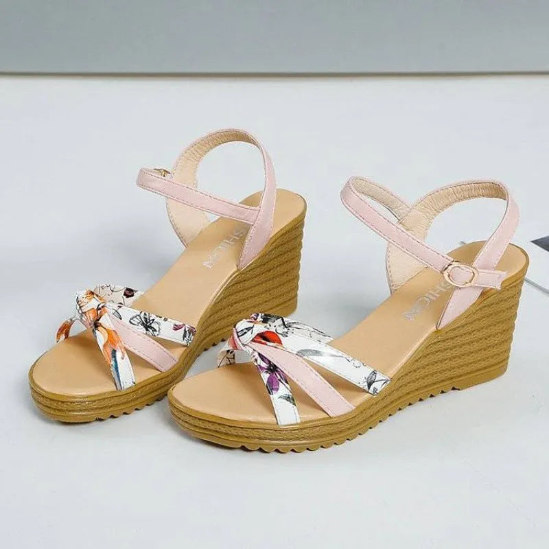 Women's pink wedge sandals with a thick platform sole and buckle strap.
