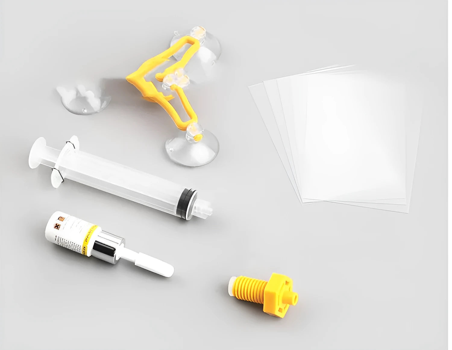 Yellow auto glass repair tool with triangle bracket and 2ml fluid on car windshield