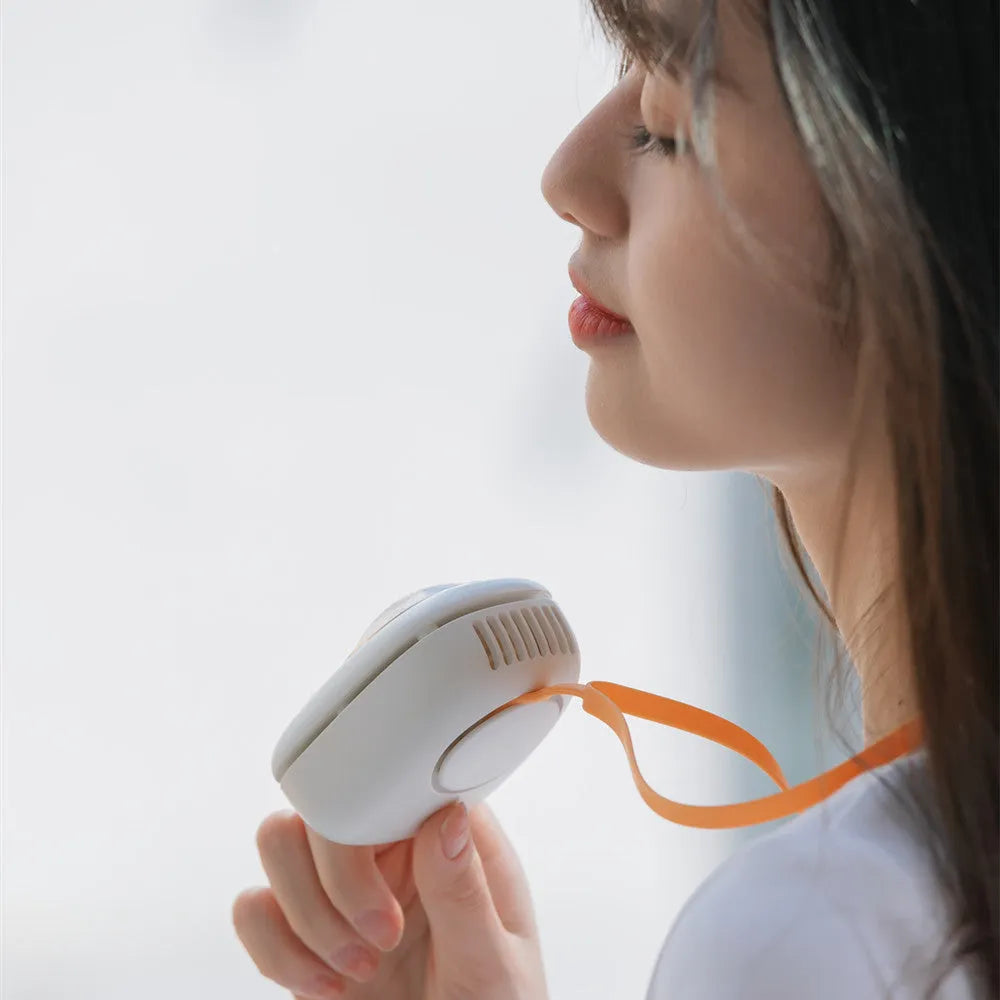 White handheld neck fan with USB port and cute animal design, shown next to its packaging.