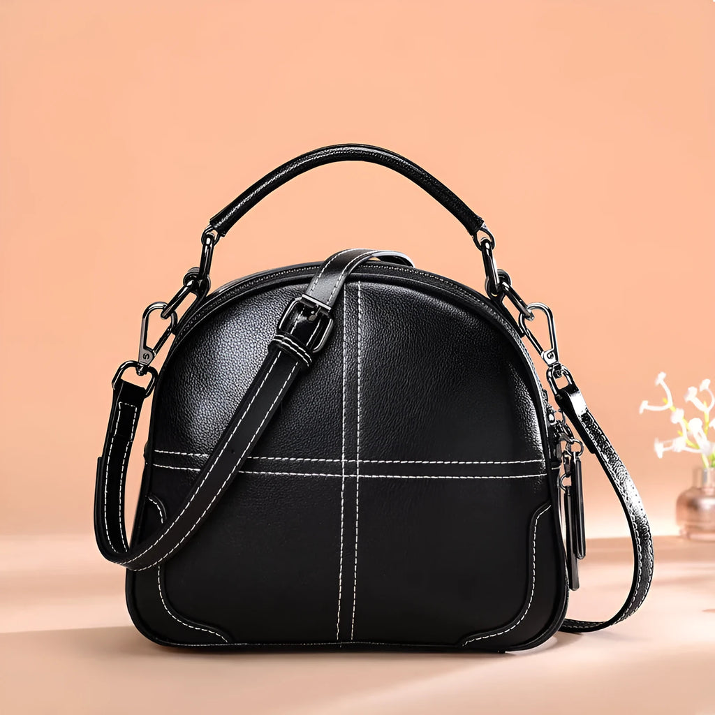 Round leather handbag with soft handle and zipper opening in wine red colour