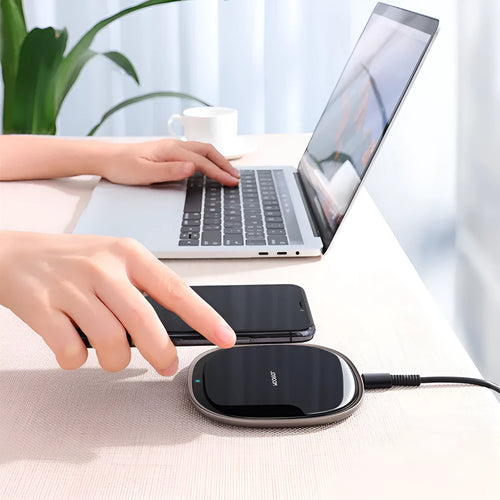 Black or white 15W wireless charger with a glass top and zinc alloy body on a desk.