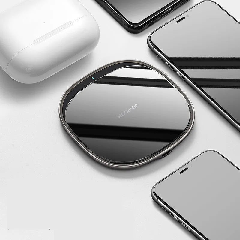 Black or white 15W wireless charger with a glass top and zinc alloy body on a desk.