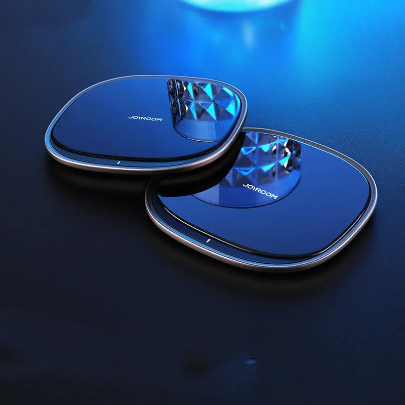 Black or white 15W wireless charger with a glass top and zinc alloy body on a desk.
