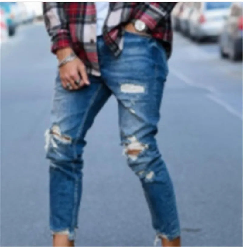 Men's blue jeans with distressed hole detailing on cotton fabric