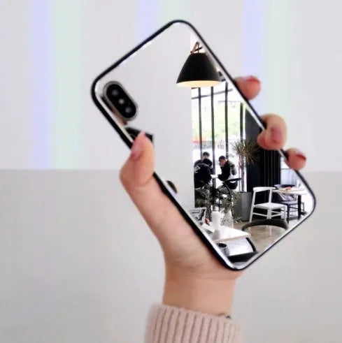 Black iPhone case with a mirrored back panel, shown next to an iPhone.