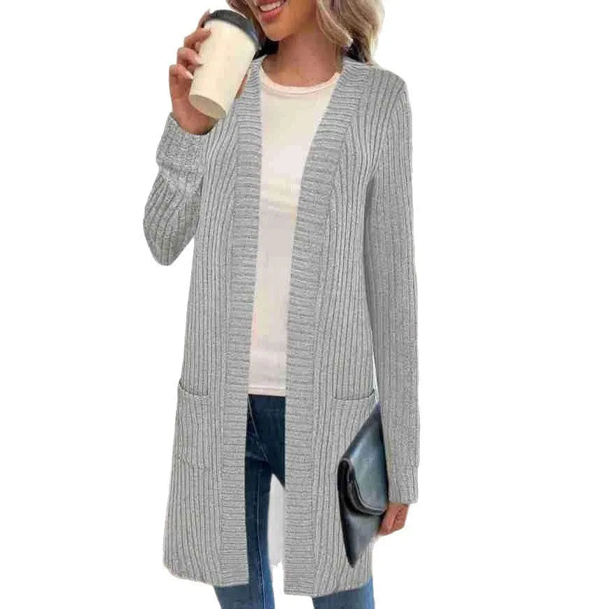 Long sleeve loose pocket knitted cardigan jacket in grey on a hanger.