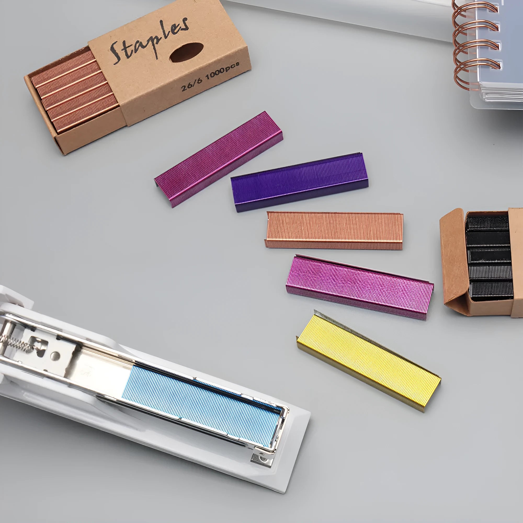 Box of 1000 metal office staples in rose gold, black, purple, and rose red colour options.