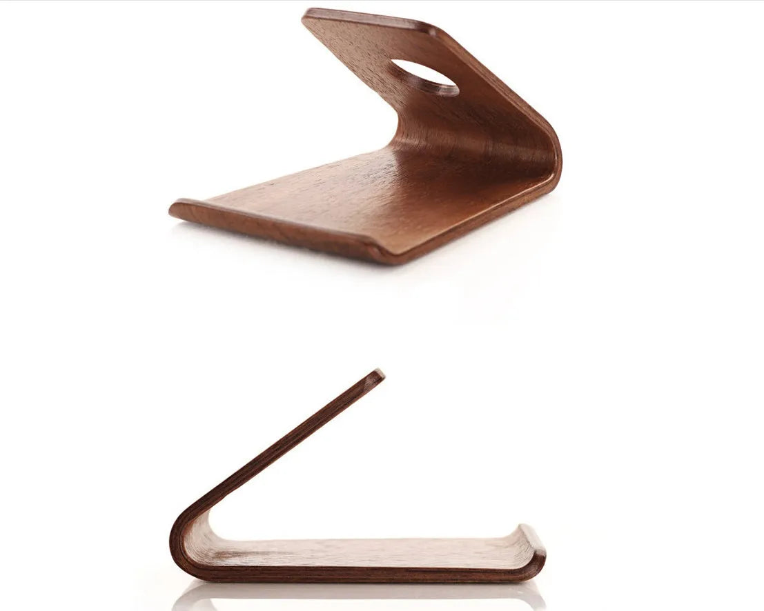 Solid walnut wooden iPhone stand holding a phone at an angle on a desk
