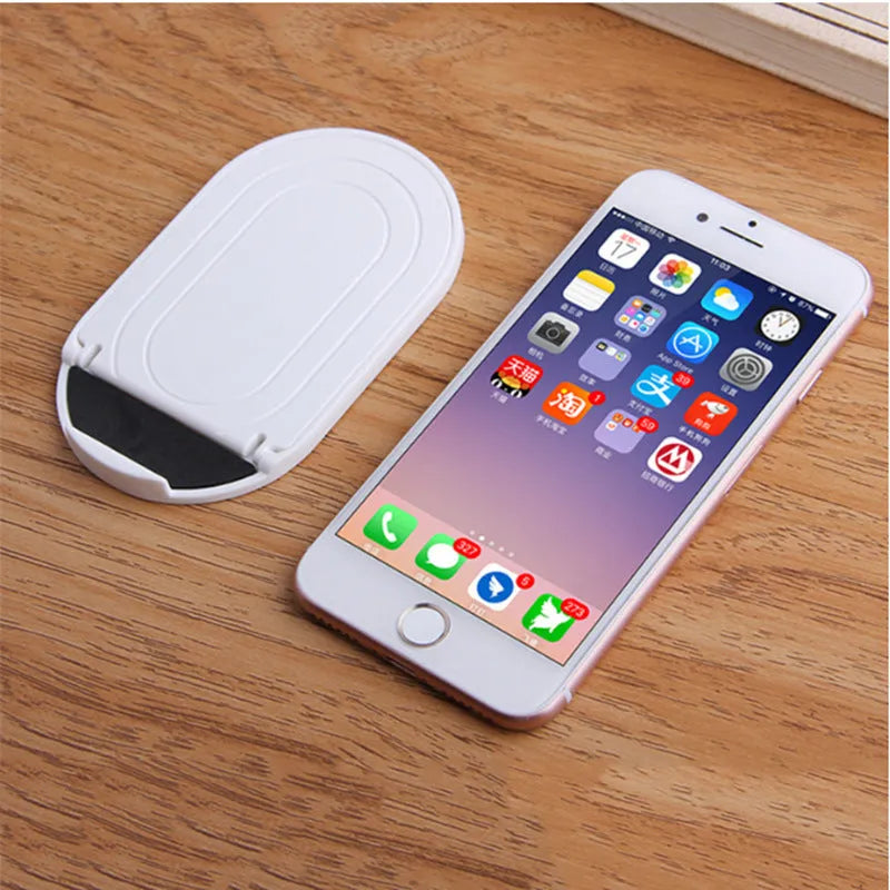 Plastic mobile phone stand with lazy bracket design shown in multiple colour options on a desk