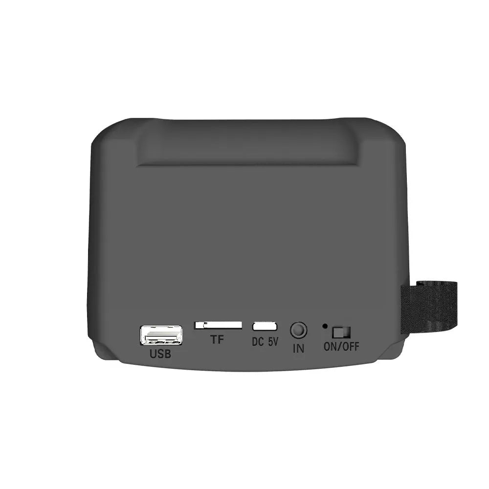 Compact portable Bluetooth speaker with USB charging cable on desktop
