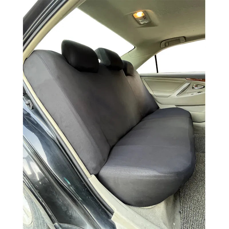 Set of blue polyester car seat covers with eyelet stitching on a vehicle seat.