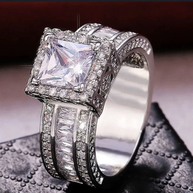 Geometric silver fashion engagement ring for women in gold or white electroplated finish on a size chart.