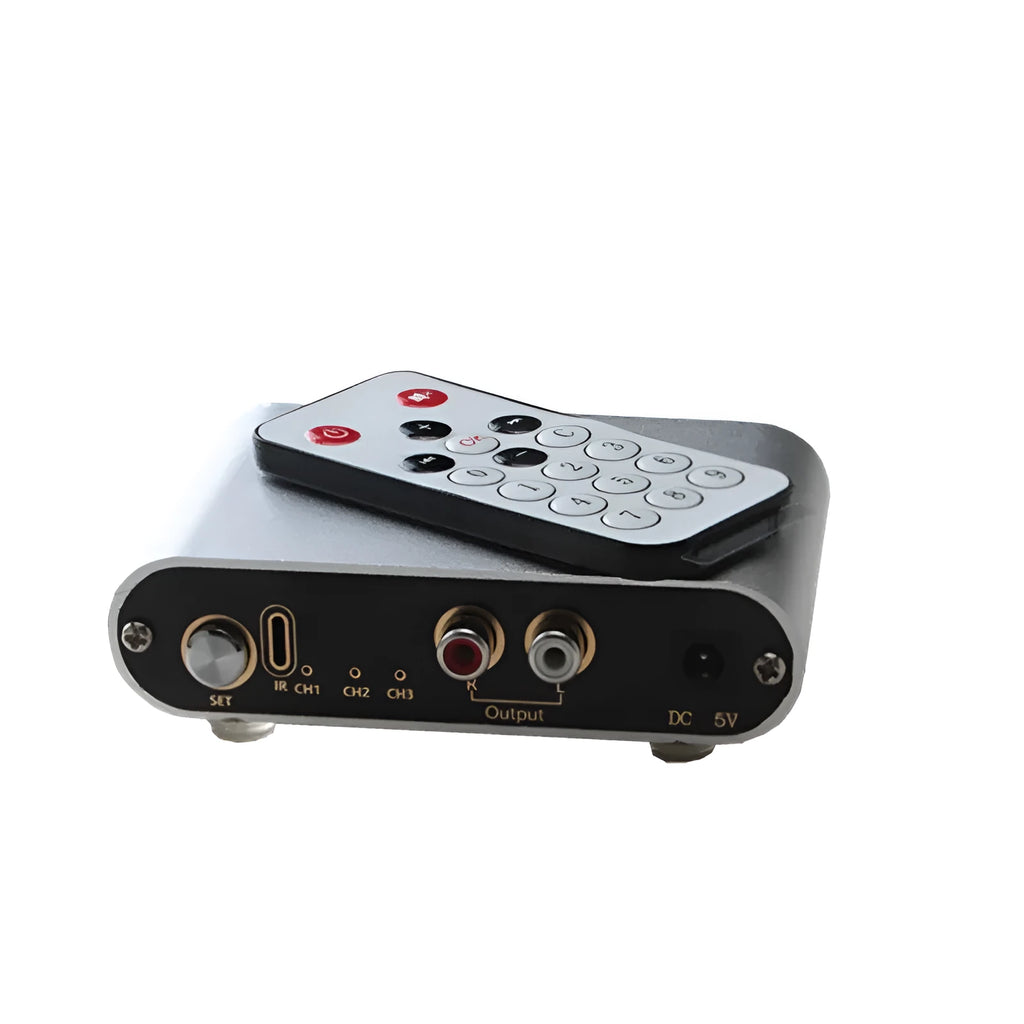 Silver aluminium audio source selector switch unit with front-panel buttons and infrared remote control.