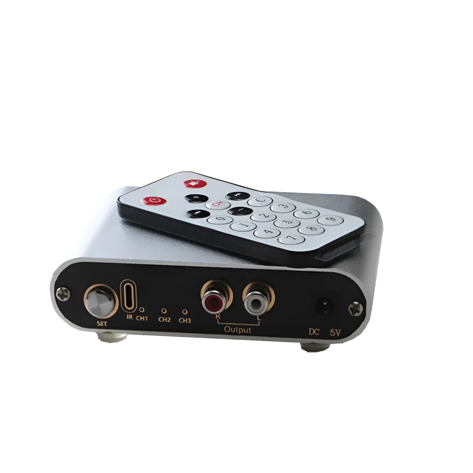 Silver aluminium audio source selector switch unit with front-panel buttons and infrared remote control.