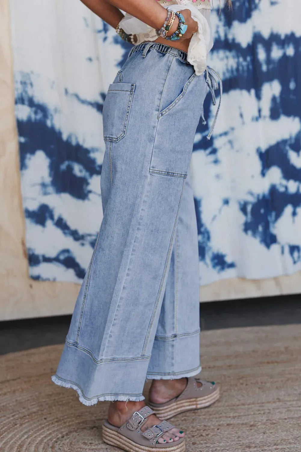 Beau blue women's wide-leg denim jeans with drawstring waist detailing and raw unfinished hem.