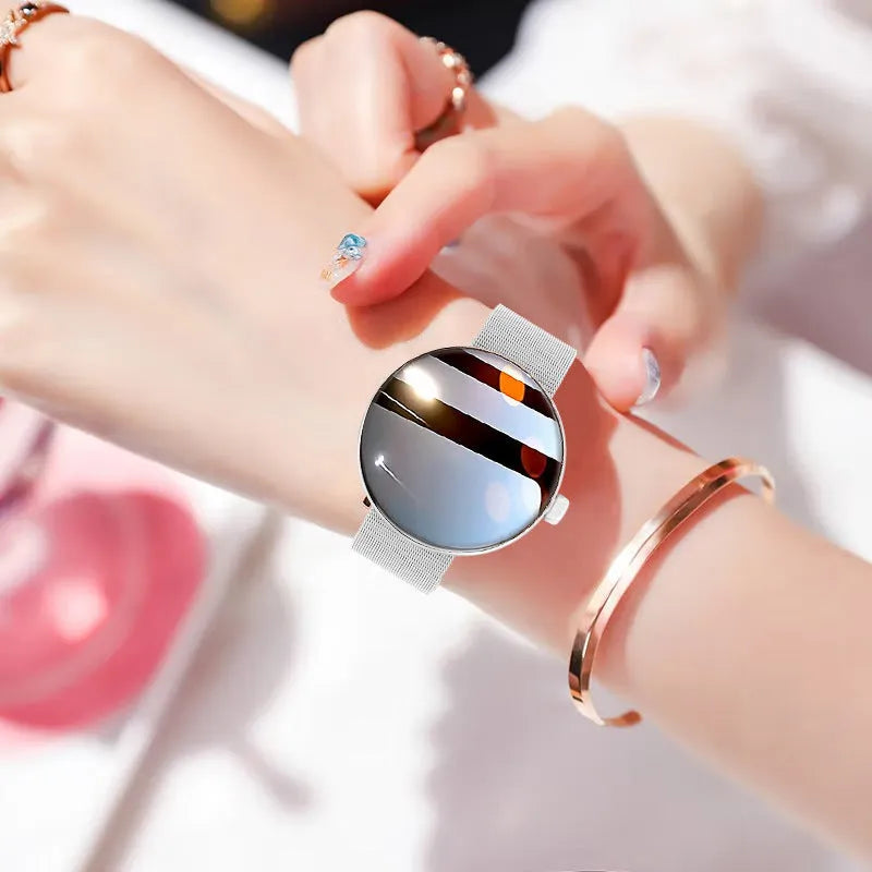 Circular smart watch for women with metal strap, showing colour touch screen display.
