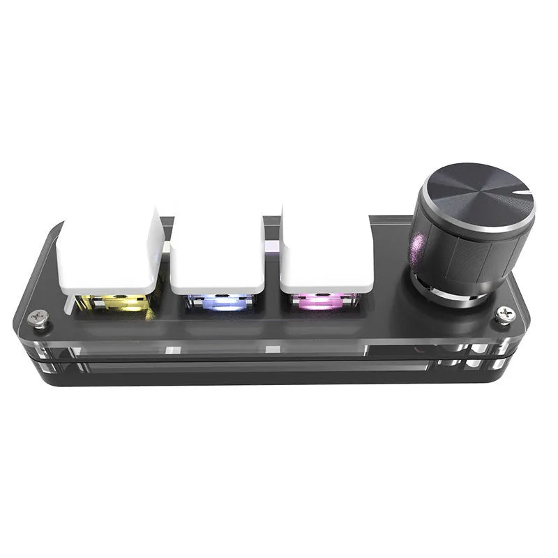 Black programmable mini keyboard with RGB backlighting on a desk next to a laptop